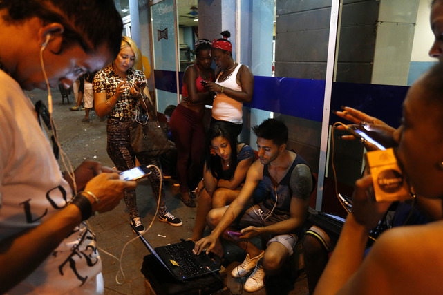 La gente se conecta a un punto de acceso WiFi en La Habana, Cuba   AP Photo/Desmond Boylan